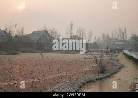 Srinagar es friert ein, die Bewohner leiden unter den Folgen der Winterperiode 21. Dezember 2023, Srinagar Kashmir, Indien : Ein Mann geht auf einer frostbedeckten Holzbrücke an einem kalten Wintermorgen in Srinagar. Die 40 Tage härteste Winterperiode Chillai-Kalan beginnt am Donnerstag in Kaschmir. Srinagar Kashmir Indien Copyright: XFirdousxNazirxEyepixxGroupx Stockfoto