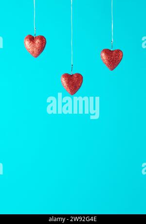 Drei rote Herzen in Fischhaken auf blauem Hintergrund. Love-Konzept. Kopierbereich Stockfoto
