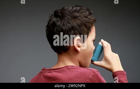 Kind mit Grippe und Inhalator Atemschutz auf grauem Hintergrund mit Personen Stock Foto Stockfoto