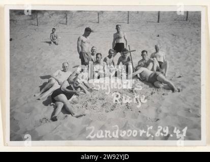 Deutsche Soldaten in Zandvoort, 1941, 1941 Fotografie Amateurfoto deutscher Soldaten von 1941 in Zandvoort. Eine Gruppe in Badehosen steht im Sand um ein hölzernes Kreuz bei einem Kameraden, der im Sand begraben ist. Auf dem Foto "Schiebel's Ruhe" auf Deutsch geschrieben? Zandvoort fotografische Unterstützung Besatzung  Krieg. Erholung  der Soldat aus dem Dienst. Die Firma, die Einheit, die Truppe... Militärdienst. In oder neben dem Wasser (am Strand) Zandvoort Stockfoto