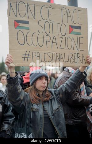 Rom, Italien. Dezember 2023. Eine Frau hält während der Demonstration, die von verschiedenen palästinensischen Gemeindeorganen in Rom organisiert wurde, ein Schild mit den Worten „es gibt keinen Frieden unter Besatzung“ und dem Aufdruck #Freepalestine hoch. Hunderte von Menschen nahmen an der Demonstration Teil, die von der palästinensischen Studentenbewegung in Italien, der Arabischen Palästinensischen Demokratischen Union, dem Verband der Palästinenser in Italien, die Palästinensische Gemeinschaft von Rom und Latium, der sich Organisationen der Zivilgesellschaft und Verbände angeschlossen haben, um zu sagen: ""stoppt den Völkermord am palästinensischen Volk"". Quelle: ZUMA Press, Inc./Alamy L. Stockfoto