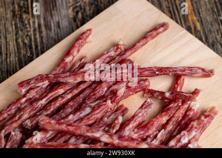 Dünne Schweinewurst mit Gewürzen, trockene dünne Wurst aus getrocknetem Schweinefleisch mit Gewürzen und Schmalz Stockfoto