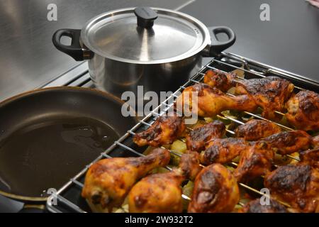 Hühnerstücke auf einem Metallgitter mit einem Backblech Gemüse wie Kartoffeln, Zucchini, Paprika, Zwiebeln, Brokkoli Stockfoto