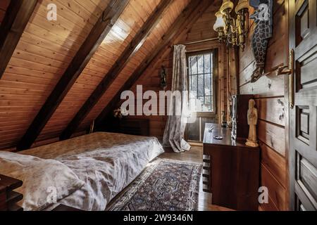 Ein Schlafzimmer mit einem Einzelbett in einer Blockhütte Stockfoto