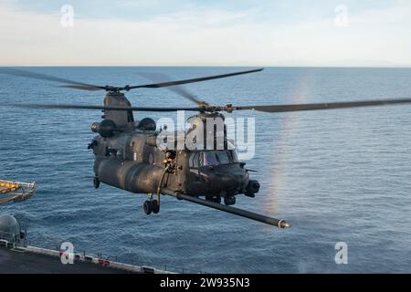 PAZIFIK (10. Dezember 2023) - Ein Chinook der US-Armee MH-47G, der dem 4. Bataillon, 160. Special Operations Aviation Regiment (Airborne), mit eingestiegenen Naval Special Warfare (NSW)-Betreibern angehört, bereitet sich auf die Landung an Bord des amphibischen Angriffsschiffs USS Boxer (LHD 4) im PAZIFIK während der Qualifikation für die gemeinsame Landung vor. Dezember 2023. Die Marine Special Warfare ist die Elite-Spezialeinsatztruppe des Landes, die einzigartig positioniert ist, um die Reichweite der Flotte zu erweitern und Dynamik und Zugang für die Joint Force in Wettbewerb und Konflikt zu gewinnen. Die 15. Marine Expeditionary Unit ist derzeit an Bord Stockfoto