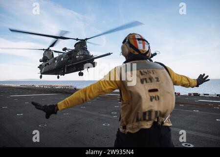 PAZIFIK (10. Dezember 2023) - Ein US-Seemann, der dem amphibischen Angriffsschiff USS Boxer (LHD 4) zugeordnet ist, führt einen MH-47G Chinook der US-Armee, der dem 4. Bataillon, 160. Special Operations Aviation Regiment (Airborne), zugeordnet ist. mit eingestiegenen Naval Special Warfare (NSW)-Betreibern auf das Flugdeck während der gemeinsamen Landungsqualifikation an Bord von Boxer im Pazifischen Ozean, 10. Dezember 2023. Die Marine Special Warfare ist die Elite-Spezialeinsatztruppe des Landes, die einzigartig positioniert ist, um die Reichweite der Flotte zu erweitern und Dynamik und Zugang für die Joint Force in Wettbewerb und Konflikt zu gewinnen. Der 15 Stockfoto