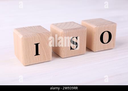 Internationale Organisation für Normung. Würfel mit der Abkürzung ISO auf weißem Holztisch, Großansicht Stockfoto
