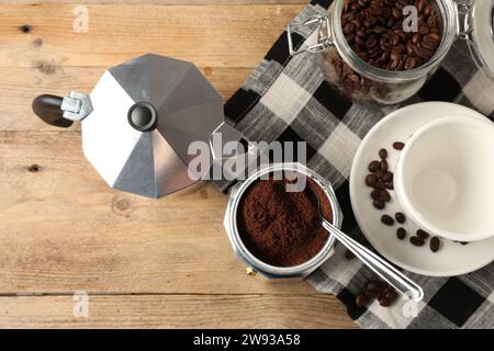 Mokakanne mit gemahlenem Kaffee, Tasse und Bohnen auf Holztisch, flach gelegt Stockfoto