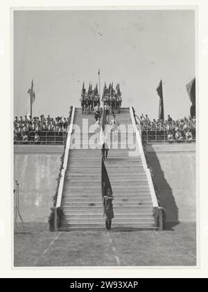 Jugendsturm im Stadion Galgenwaard, 1942 Foto Eine lange Reihe von Mitgliedern des Jeugdstorm kommt am 20. Juni 1942 im Stadion Galgenwaard in Utrecht herunter. Im Stadion werden sie den 3000 vereidigten Führungskräften des NSB beiwohnen, unten auf der Treppe steht ein Wehrmachtssoldat mit einer Flagge. Es gibt Mitglieder des Jugendsturms auf den Tribünen, links und rechts der Treppe. Ein Teil bringt den NSB-Gruß: Gestreckter Arm wie der Hitler-Gruß und Ruf: Houzee. Die Eidesfeier war das Ergebnis eines Kompromisses zwischen den Deutschen und der NSB, die Deutschen wollten keinen Eid o Stockfoto