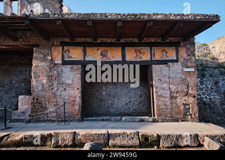 Neapel, Italien - 8. November 2023: Altes Geschäft und Gemälde von 4 menschlichen Gesichtsfiguren im Archäologischen Park von Pompeji Stockfoto