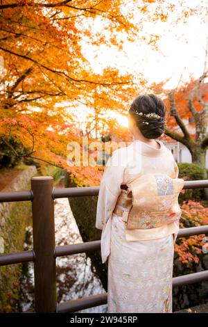 Japanische Kimono-Frauen Porträtfotografie. Ahornblätter färben sich im Herbst auf dem Kyoto Philosopher's Path (Tetsugaku No Michi) rot. Stockfoto