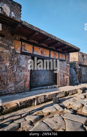 Neapel, Italien - 8. November 2023: Altes Geschäft und Gemälde von 4 menschlichen Gesichtsfiguren im Archäologischen Park von Pompeji Stockfoto