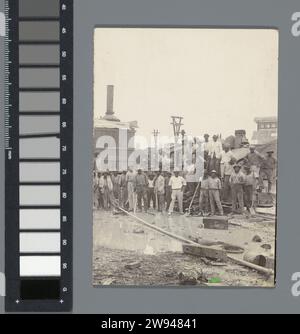 Gruppenfoto der Fabrikarbeiter, 1925 - 1927 Foto Gruppenfoto der Fabrikarbeiter in Moengo, posiert bei einer Lokomotive auf dem Fabrikgelände. Teil des Ensembles mit Fotos der Familie des Ingenieurs Jetten in der Bergbaustadt Moengo in Suriname. Suriname fotografische Unterstützung Gelatine Silberdruck anonyme historische Personen in einer Gruppe, in einem Gruppenporträt dargestellt. Fabrikgebäude Moengo Stockfoto