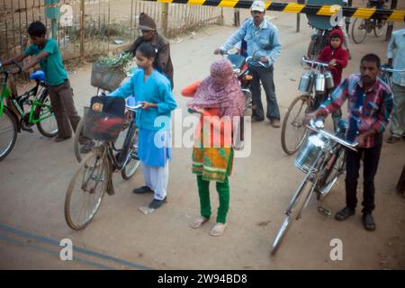 Lokale ländliche Dorfbewohner Indiens stehen an einer Bahnhaltestelle, die jungen Männer und Frauen haben ihre Fahrräder für den Transport, in den Dörfern Indiens. Stockfoto