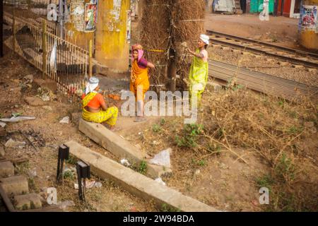 Drei hart arbeitende indische Frauen, die zwischen den Bahngleisen eine Pause machen. Mitarbeiter der indischen Eisenbahn. Unterste Ebene. Stockfoto