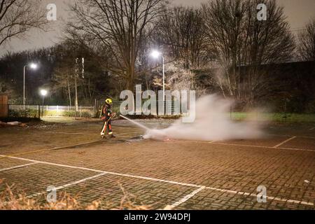 Feuerwehrmann löscht Kleinbrand am Silvesterabend in Nieuwerkerk aan den IJssel in den Niederlanden Stockfoto