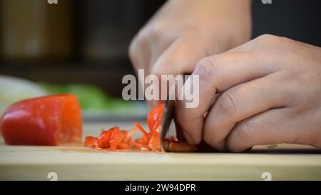 Der Küchenchef schneidet, schneidet und schneidet eine lebendige Auswahl an frischem Gemüse und Obst. Der Küchenchef schneidet, hackt und schneidet frisches Gemüse, Obst und Gemüse. Stockfoto