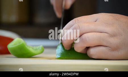 Der Küchenchef schneidet, schneidet und schneidet eine lebendige Auswahl an frischem Gemüse und Obst. Der Küchenchef schneidet, hackt und schneidet frisches Gemüse, Obst und Gemüse. Stockfoto