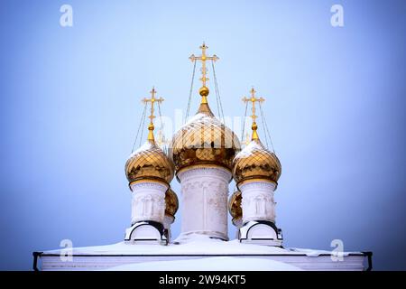 Orthodoxe Kirche mit goldenen Kuppeln und Kreuzen im Winter vor dem blauen Himmel Stockfoto