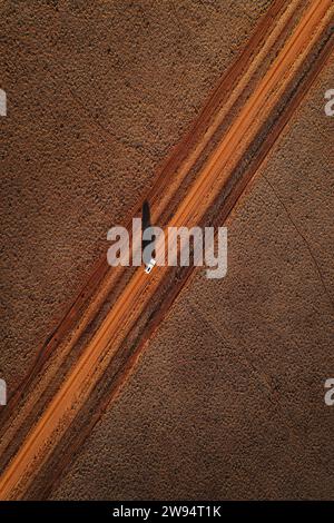 Luftaufnahme eines Autos auf einer abgelegenen Feldstrecke im Outback. Stockfoto