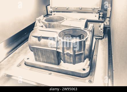 Foto im alten Vintage-Stil. Ein Modell mit Stützen, die in einer Lasersintermaschine erstellt wurden, bleibt in der Arbeitskammer. DMLS, SLM, SLS-TECHNOLOGIE. Fortschrittliche moderne Additivtechnologie. Stockfoto