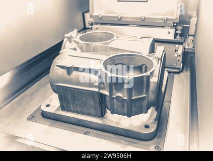 Foto im alten Vintage-Stil. Ein Modell mit Stützen, die in einer Lasersintermaschine erstellt wurden, bleibt in der Arbeitskammer. DMLS, SLM, SLS-TECHNOLOGIE. Fortschrittliche moderne Additivtechnologie. Stockfoto