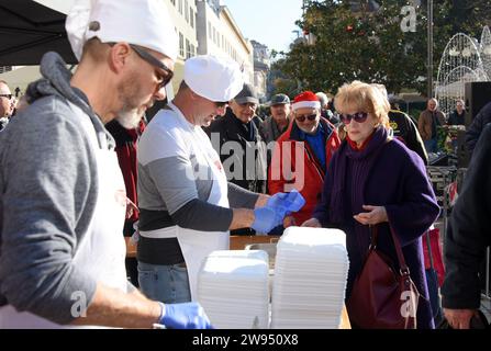 Pula, Kroatien. Dezember 2023. Personen, die einen Teil eines traditionellen Risottos mit Meeresfrüchten (Risotto ai Fruitti di Mare) während eines traditionellen Weihnachtsessens am Weihnachtsabend auf dem Stadtmarkt in Pula, Kroatien, erhalten am 24. Dezember 2023. Foto: SASA Miljevic/PIXSELL Credit: Pixsell/Alamy Live News Stockfoto