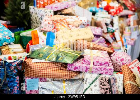 Berlin, Deutschland. Dezember 2023. Geschenke liegen auf einem Tisch bei einem kostenlosen Weihnachtsessen des Arche und Hofbräu Berlin für Kinder und Familien mit benachteiligten Hintergründen im Hofbräu Wirtshaus. Quelle: Christoph Soeder/dpa/Alamy Live News Stockfoto