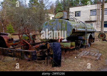 Ein rostiger alter Tankwagen, der in einem bewaldeten Gebiet verlassen wurde. Stockfoto