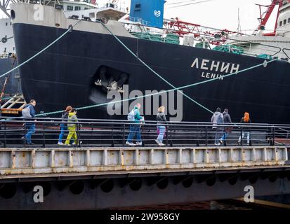 Murmansk, Russland - 22. Juni 2022: Die Menschen laufen entlang des Piers zum verankerten Atomeisbrecher Lenin, Seehafen Murmansk Stockfoto