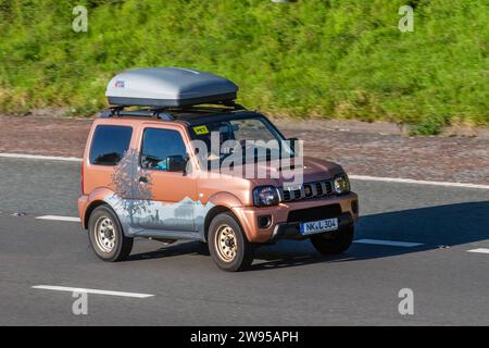 2017 maßgeschneiderte deutsche Suzuki Jimny  Europäisches Ursprungskennzeichen. LHD-SUV mit Dachreling und Antriebsstrang-Dachkasten mit Bergaufklebern, Aufklebern und Baumbewaldgrafiken. Suzuki Jimny SZ4 Auto Sport Nutzfahrzeug auf der Autobahn M6 in der Nähe von Preston in Lancashire, Großbritannien Stockfoto