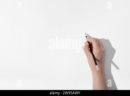 Leere Stelle auf weißem Skizzenbuch und Hand mit Bleistift Stockfoto