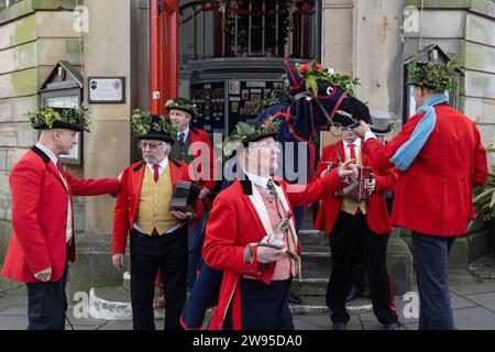 Ichmond, North Yorkshire, Großbritannien. Dezember 2023. Die Heiligabend-Tradition „Poor Old Hoss“ in Richmond, North Yorkshire. Auch bekannt als „T'owd Hoss“, und vermutlich aus dem 18. Jahrhundert, führt eine Gruppe von „Mummern“ in Jägerkostümen das Pferd durch das Stadtzentrum von Richmond, geht in Pubs und Cafés und singt sein besonderes Lied (24. Dezember 2023). (Foto: Pat Scaasi | MI News) Credit: MI News & Sport /Alamy Live News Credit: MI News & Sport /Alamy Live News Stockfoto