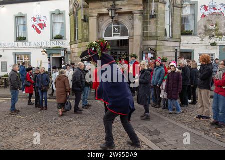 Ichmond, North Yorkshire, Großbritannien. Dezember 2023. Die Heiligabend-Tradition „Poor Old Hoss“ in Richmond, North Yorkshire. Auch bekannt als „T'owd Hoss“, und vermutlich aus dem 18. Jahrhundert, führt eine Gruppe von „Mummern“ in Jägerkostümen das Pferd durch das Stadtzentrum von Richmond, geht in Pubs und Cafés und singt sein besonderes Lied (24. Dezember 2023). (Foto: Pat Scaasi | MI News) Credit: MI News & Sport /Alamy Live News Credit: MI News & Sport /Alamy Live News Stockfoto