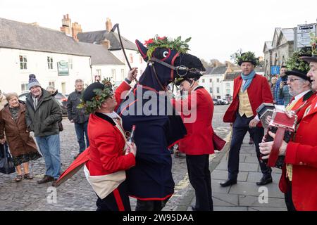 Ichmond, North Yorkshire, Großbritannien. Dezember 2023. Die Heiligabend-Tradition „Poor Old Hoss“ in Richmond, North Yorkshire. Auch bekannt als „T'owd Hoss“, und vermutlich aus dem 18. Jahrhundert, führt eine Gruppe von „Mummern“ in Jägerkostümen das Pferd durch das Stadtzentrum von Richmond, geht in Pubs und Cafés und singt sein besonderes Lied (24. Dezember 2023). (Foto: Pat Scaasi | MI News) Credit: MI News & Sport /Alamy Live News Credit: MI News & Sport /Alamy Live News Stockfoto