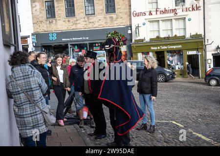 Ichmond, North Yorkshire, Großbritannien. Dezember 2023. Die Heiligabend-Tradition „Poor Old Hoss“ in Richmond, North Yorkshire. Auch bekannt als „T'owd Hoss“, und vermutlich aus dem 18. Jahrhundert, führt eine Gruppe von „Mummern“ in Jägerkostümen das Pferd durch das Stadtzentrum von Richmond, geht in Pubs und Cafés und singt sein besonderes Lied (24. Dezember 2023). (Foto: Pat Scaasi | MI News) Credit: MI News & Sport /Alamy Live News Credit: MI News & Sport /Alamy Live News Stockfoto