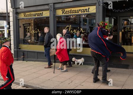 Ichmond, North Yorkshire, Großbritannien. Dezember 2023. Die Heiligabend-Tradition „Poor Old Hoss“ in Richmond, North Yorkshire. Auch bekannt als „T'owd Hoss“, und vermutlich aus dem 18. Jahrhundert, führt eine Gruppe von „Mummern“ in Jägerkostümen das Pferd durch das Stadtzentrum von Richmond, geht in Pubs und Cafés und singt sein besonderes Lied (24. Dezember 2023). (Foto: Pat Scaasi | MI News) Credit: MI News & Sport /Alamy Live News Credit: MI News & Sport /Alamy Live News Stockfoto