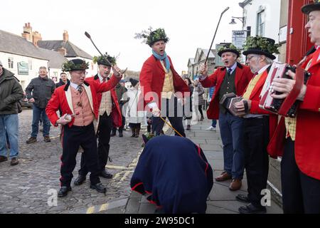 Ichmond, North Yorkshire, Großbritannien. Dezember 2023. Die Heiligabend-Tradition „Poor Old Hoss“ in Richmond, North Yorkshire. Auch bekannt als „T'owd Hoss“, und vermutlich aus dem 18. Jahrhundert, führt eine Gruppe von „Mummern“ in Jägerkostümen das Pferd durch das Stadtzentrum von Richmond, geht in Pubs und Cafés und singt sein besonderes Lied (24. Dezember 2023). (Foto: Pat Scaasi | MI News) Credit: MI News & Sport /Alamy Live News Credit: MI News & Sport /Alamy Live News Stockfoto