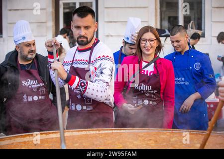 Kroatien, Split 241223. Etwa fünftausend Portionen Kabeljau und die gleiche Anzahl von Krapfen wurden in Peskaria in Split im Rahmen des Split with Love Events verteilt, das traditionell am Heiligabend stattfindet. Auf dem Foto: Bojan Ivosevic i Marijana Puljak. Foto: SASA Buric / CROPIX Copyright: XSasaxBuricx/xCROPIXxSasaxBuricx bakalar peskarija bozic17-241223 Stockfoto