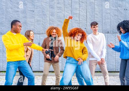 Vielfältige und multiethnische Freunde feiern und tanzen auf der Straße Stockfoto