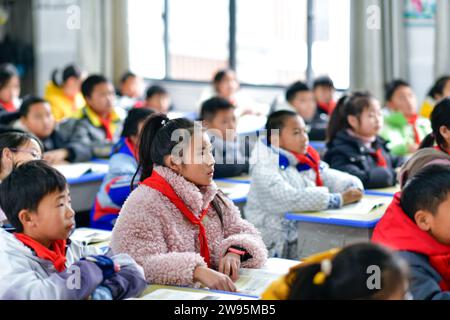 (231224) -- ANSHUN, 24. Dezember 2023 (Xinhua) -- Ji Xue (2. L) besucht eine Schule im Bezirk Xixiu der Stadt Anshun, südwestchinesische Provinz Guizhou, 22. Dezember 2023. Vor fünf Jahren begannen die sechsjährige Ji Xue und ihre Familie aus der ethnischen Gruppe der Miao ein neues Leben. Dank der Bemühungen zur Armutsbekämpfung wurden sie in ein neues Zuhause aus unwirtlichen Bergregionen und abgelegenen Gebieten umgesiedelt. In den letzten fünf Jahren sind die Unterstützungseinrichtungen in der Umsiedlungsgemeinschaft, in der Ji heute lebt, immer besser geworden. Früher dauerte es mehr als zwei Stunden, bis Ji zur Schule ging, auf einer Bergstraße Stockfoto