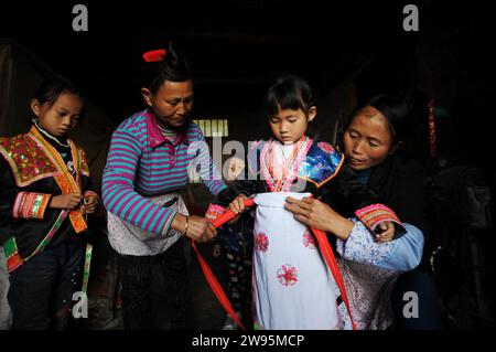 (231224) -- ANSHUN, 24. Dezember 2023 (Xinhua) -- dieses Foto vom 22. April 2018 zeigt Ji Xue in neuen Kleidern der ethnischen Gruppe Miao, bevor er in ein neues Zuhause im Dorf Longtan im Bezirk Xixiu der Stadt Anshun in der Provinz Guizhou im Südwesten Chinas aufbricht. Vor fünf Jahren begannen die sechsjährige Ji Xue und ihre Familie aus der ethnischen Gruppe der Miao ein neues Leben. Dank der Bemühungen zur Armutsbekämpfung wurden sie in ein neues Zuhause aus unwirtlichen Bergregionen und abgelegenen Gebieten umgesiedelt. In den letzten fünf Jahren sind die Unterstützungseinrichtungen in der Umsiedlungsgemeinschaft, in der Ji heute lebt, immer besser geworden. Stockfoto