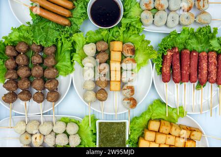 Frittierte Fleischbällchen auf Spießen aus verschiedenen Wurst- und Wurstsorten, gemischt mit Mehl und Gewürzen mit köstlicher würziger Sauce und Salat als Beilage. D Stockfoto