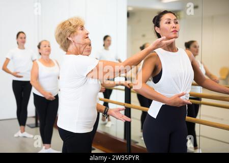 Frauen trainieren Ballettbewegungen mit Trainer Stockfoto