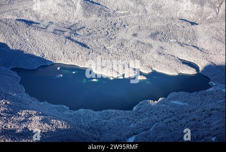 Grainau, Deutschland. Dezember 2023. Der Eibsee ist von einer verschneiten Winterlandschaft umgeben. Quelle: Matthias Balk/dpa/Alamy Live News Stockfoto