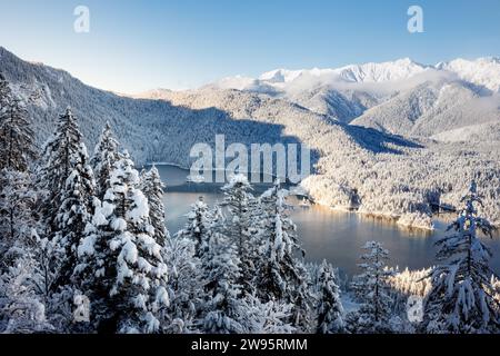 Grainau, Deutschland. Dezember 2023. Der Eibsee ist von einer verschneiten Winterlandschaft umgeben. Quelle: Matthias Balk/dpa/Alamy Live News Stockfoto