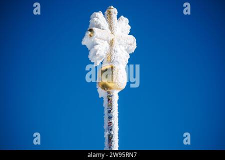 Grainau, Deutschland. Dezember 2023. Das vereiste Gipfelkreuz ist auf dem Gipfel der Zugspitze zu sehen. Quelle: Matthias Balk/dpa/Alamy Live News Stockfoto