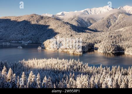 Grainau, Deutschland. Dezember 2023. Der Eibsee ist von einer verschneiten Winterlandschaft umgeben. Quelle: Matthias Balk/dpa/Alamy Live News Stockfoto