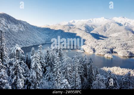 Grainau, Deutschland. Dezember 2023. Der Eibsee ist von einer verschneiten Winterlandschaft umgeben. Quelle: Matthias Balk/dpa/Alamy Live News Stockfoto