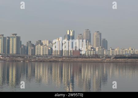 Wohngebäude im Bezirk Gwangjin und ihre Reflexion im Wasser des Han-Flusses aus Sicht vom Jamsil Hangang Park Stockfoto